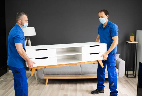 Professional Movers Moving TV Console Furniture In Face Mask